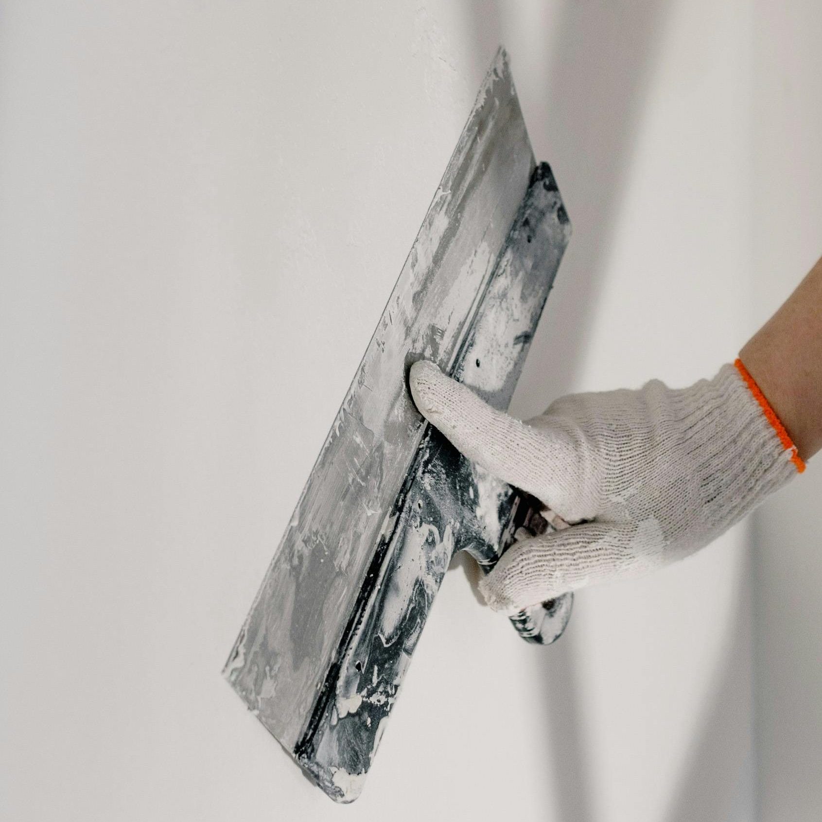 image présentant le service "plâtrerie".
on y voit la main d'un artisan entrain d'appliquer du plâtre sur un mur à l'aide d'un instrument spécifique.